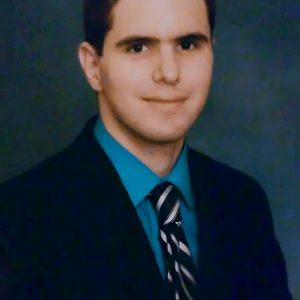 Ramiro Valdes former attorney now a poet in a blue suit and blue yellow striped tie.